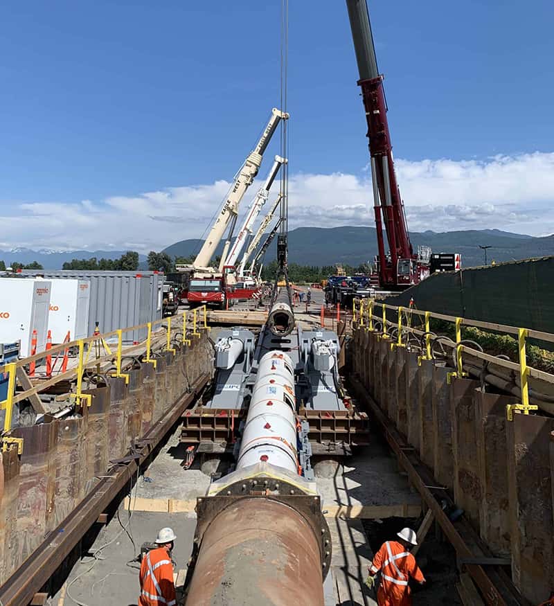 Cranes lining up precast pipe segments